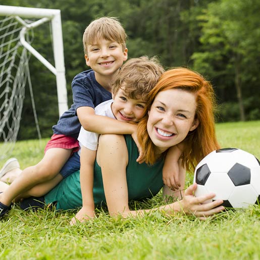 Mutter spielt mit ihren Söhnen Fußball